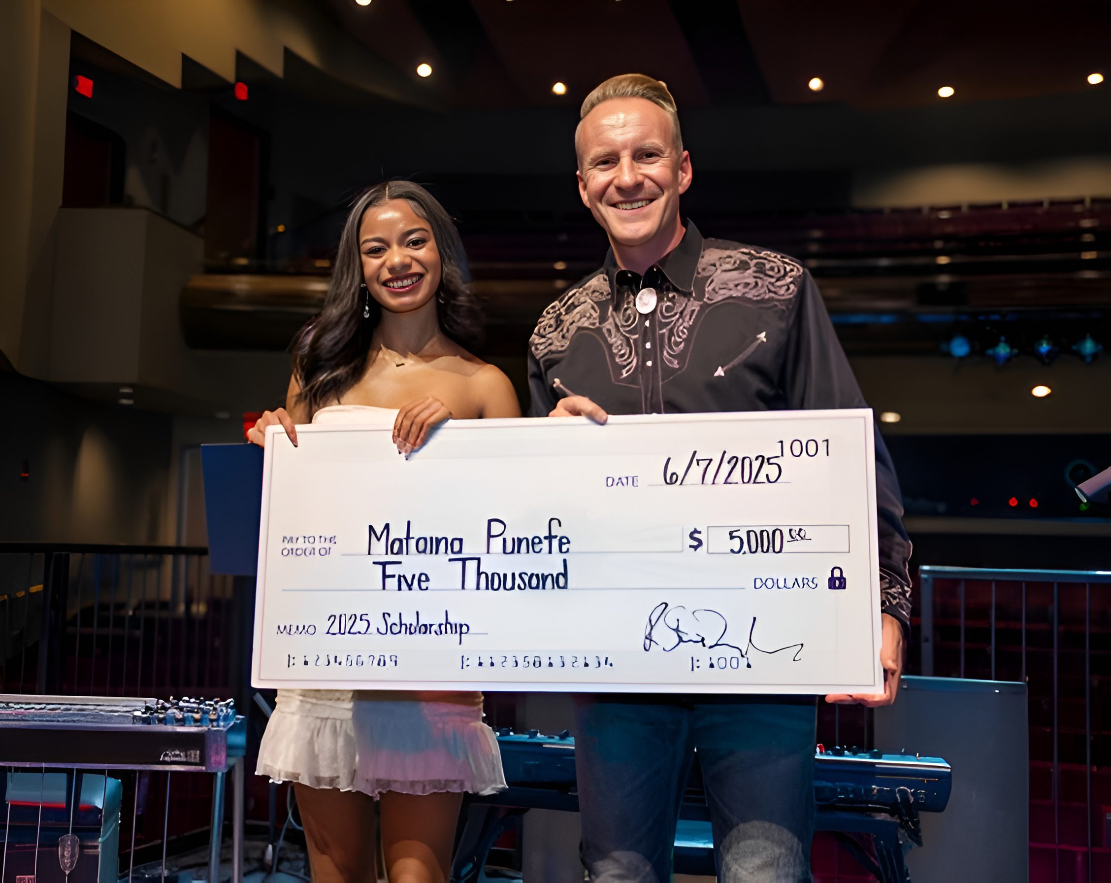 Two people holding a large check.