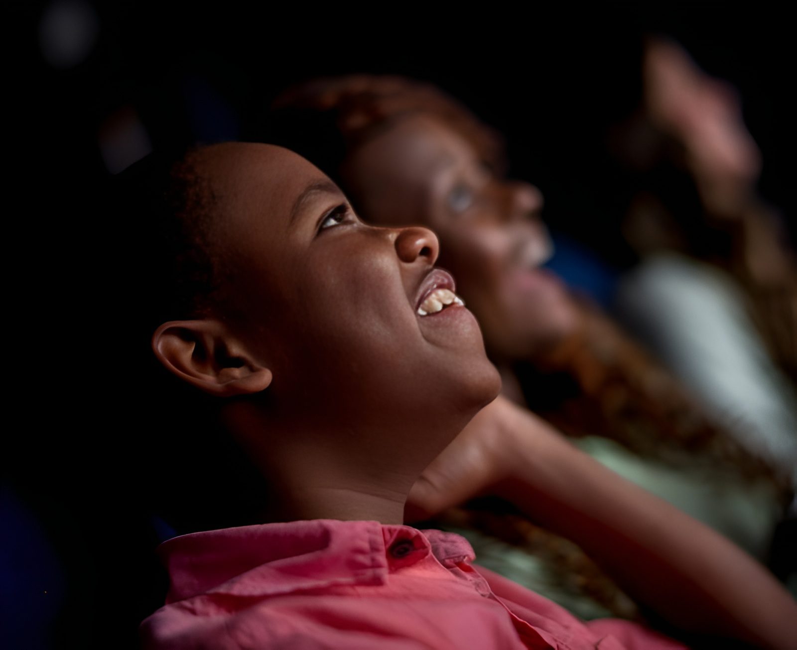 People smiling while watching a movie.